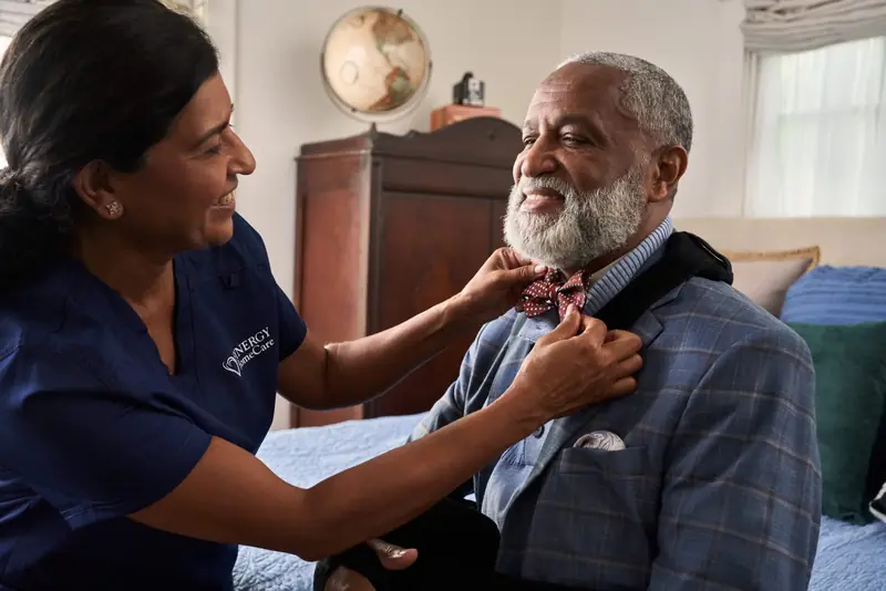 A senior woman and her caregiver laughing together, at ease and happy