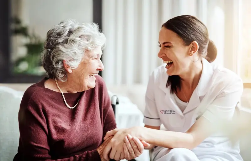 A daughter and her mother sitting peacefully together, at ease knowing care is handled